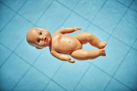Naked Baby Doll Floating On Water In A Stock